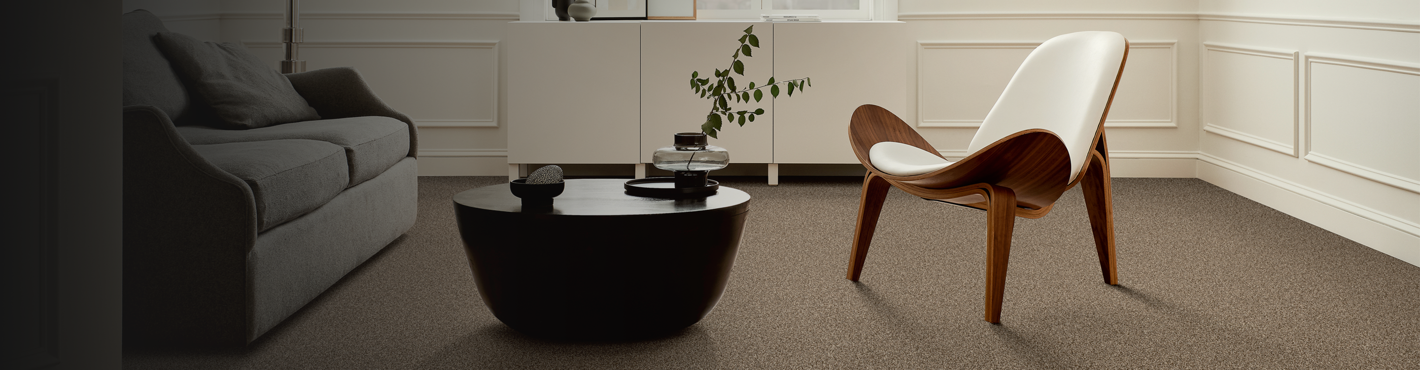 neutral toned carpet in living room with midcentury modern char and table